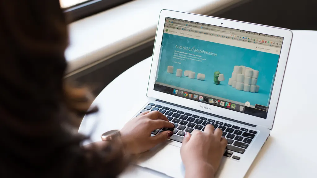 A person browsing a website on a laptop at a desk.